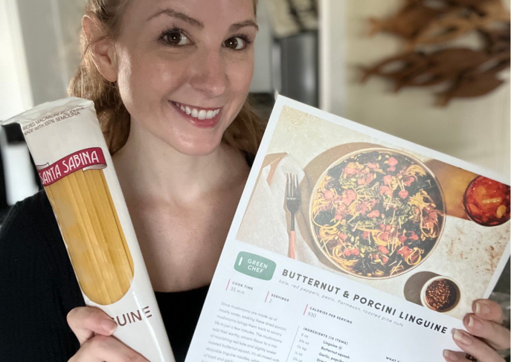 woman holding pasta noodles and recipe card