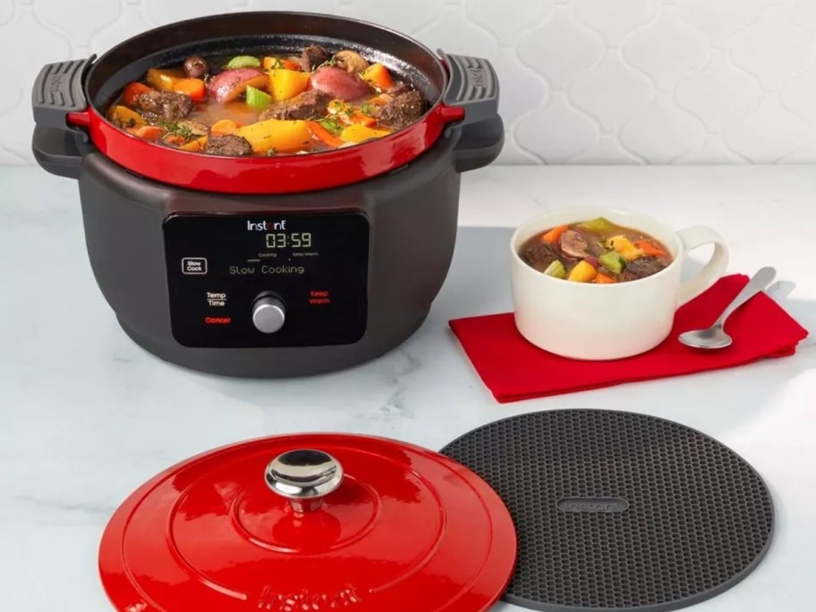 a black and red Instant Pot Dutch Oven with food cooked in it on a kitchen counter