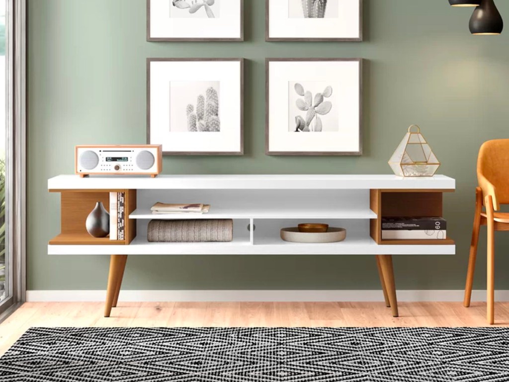 white media console with radio sitting on it next to a green wall 