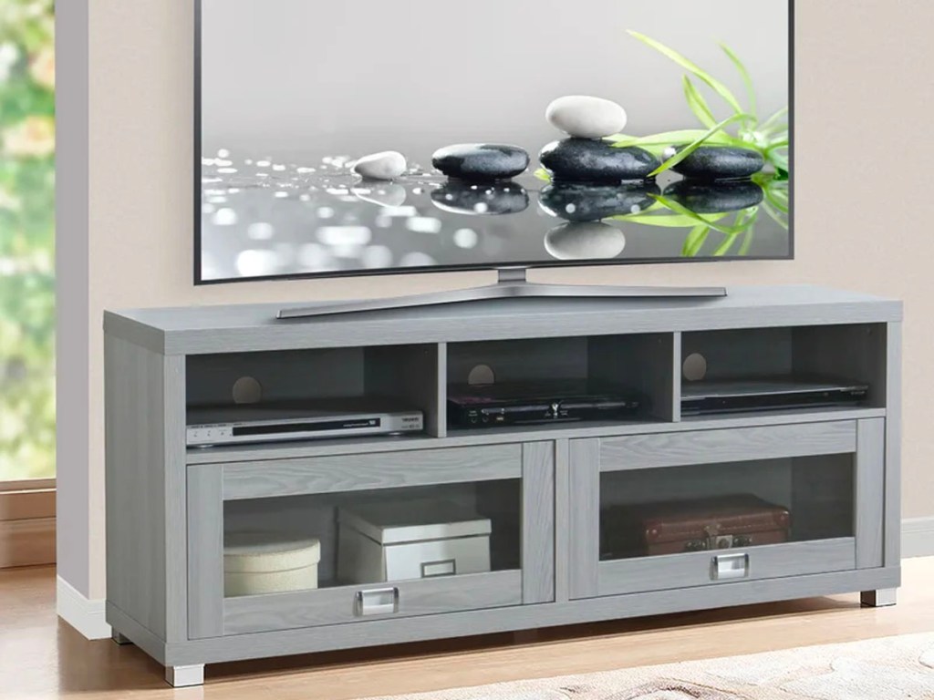 gray tv stand with tv sitting on it in living room