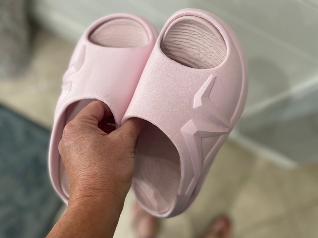 hand holding pink slide sandals