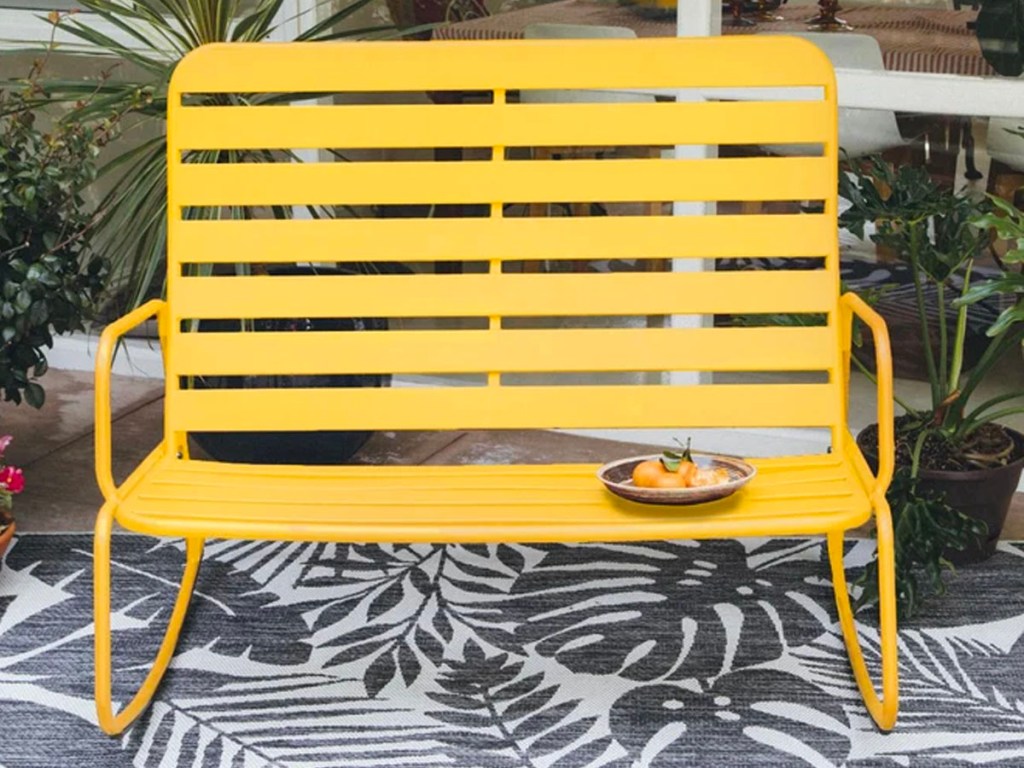 yellow metal rocking bench on white and gray rug
