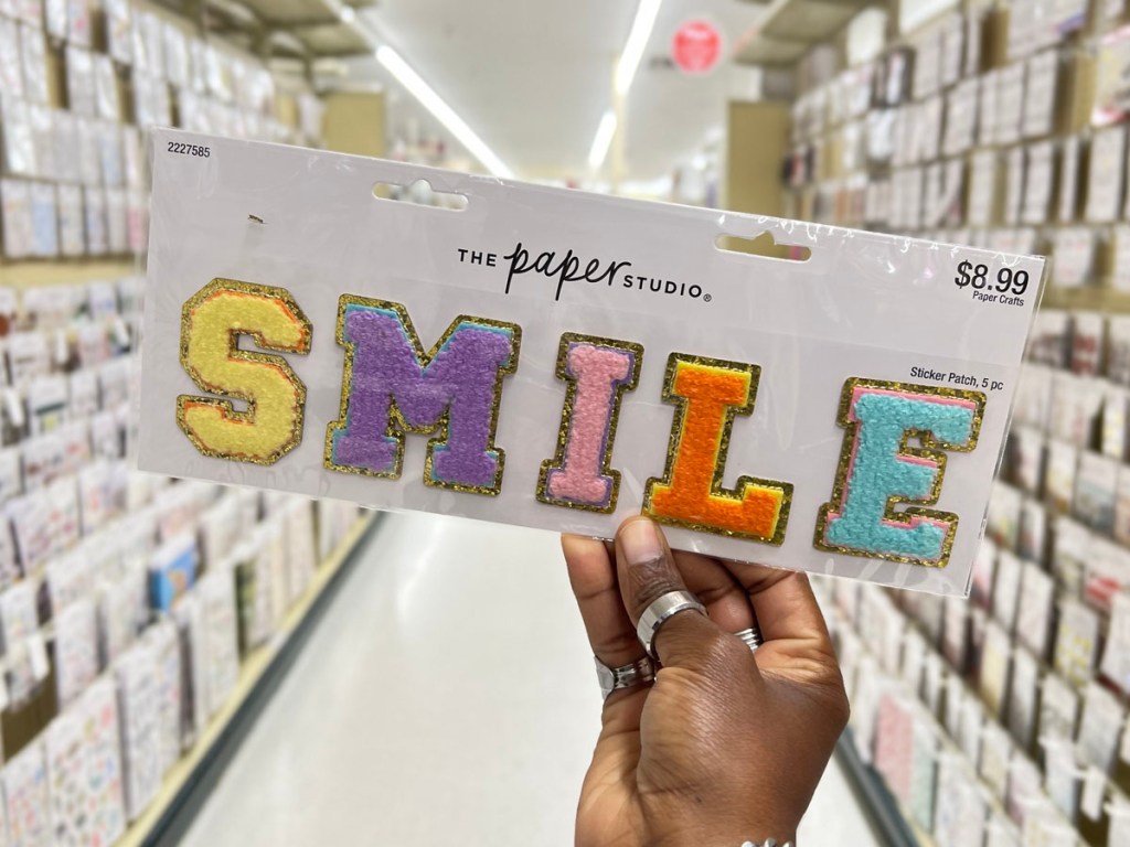 hand holding smile iron on patches in hobby lobby