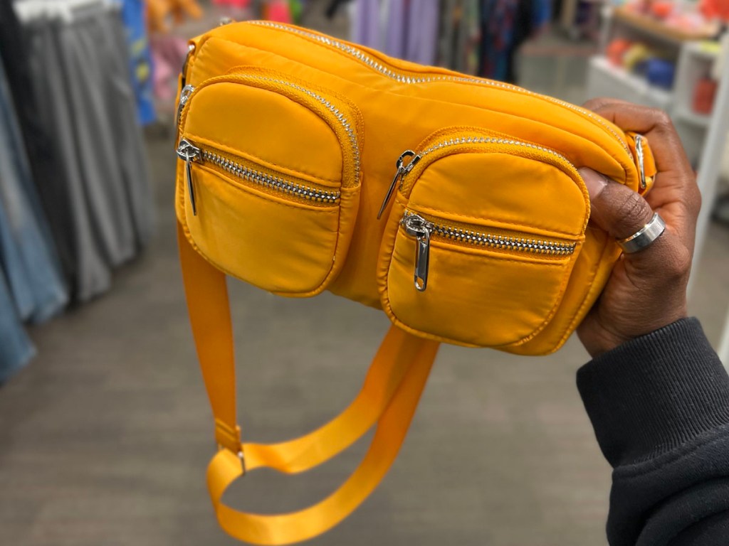 hand holding orange crossbody purse