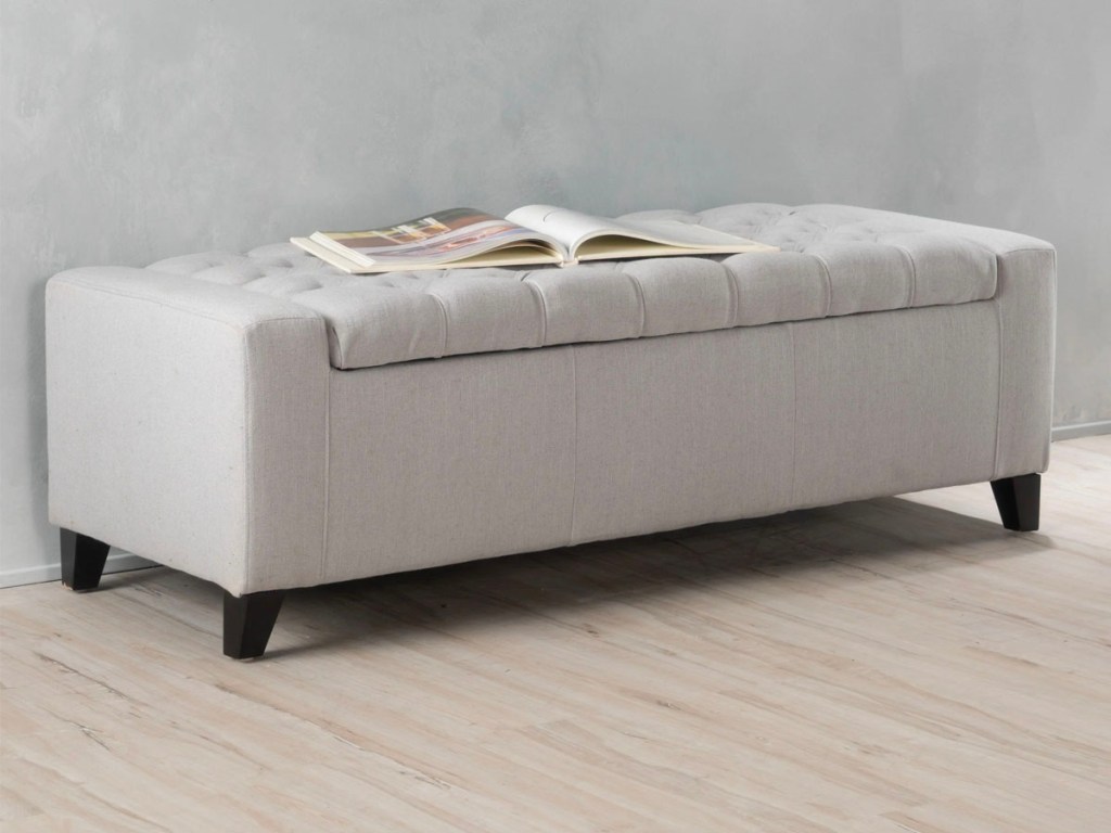beige entryway bench with book laying on top 