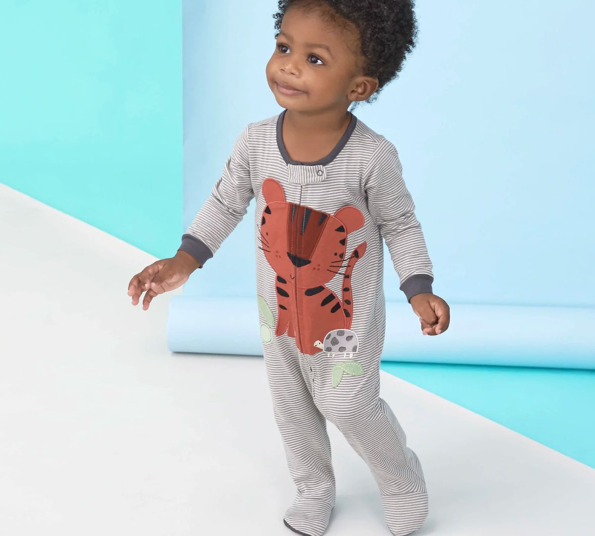 a little boy wearing a onesie from the 3-Pack Baby Boys Safari Sleep N Plays