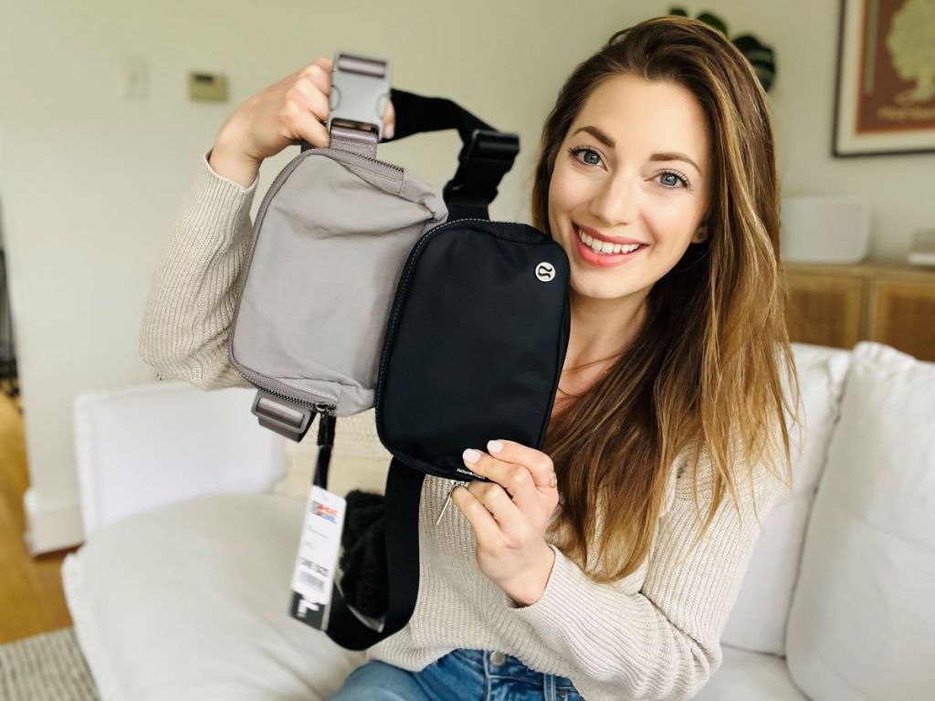 Woman holding a tan belt bag and a black belt bag