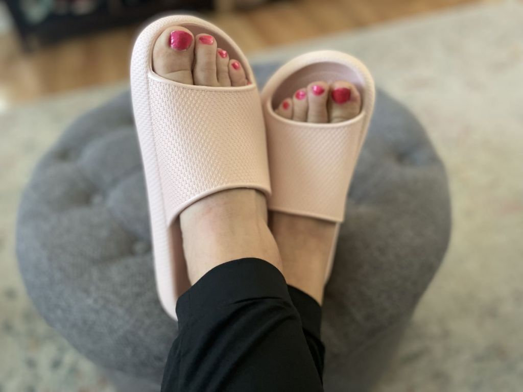 Person wearing a pair of pink slide sandals