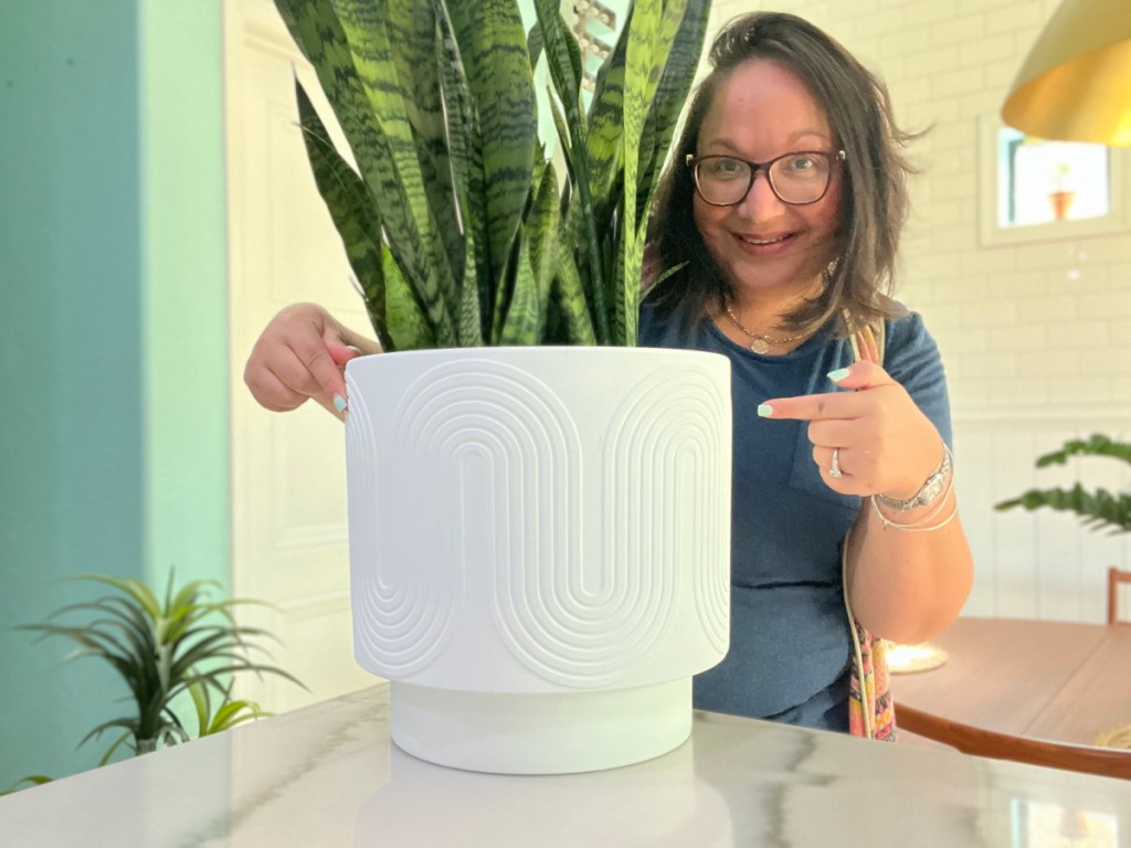 Woman standing next to her Amy planter from Walmart which is holding snake grass