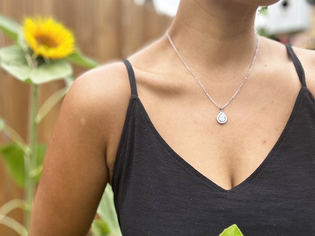 woman in black dress with a silver teardrop necklace