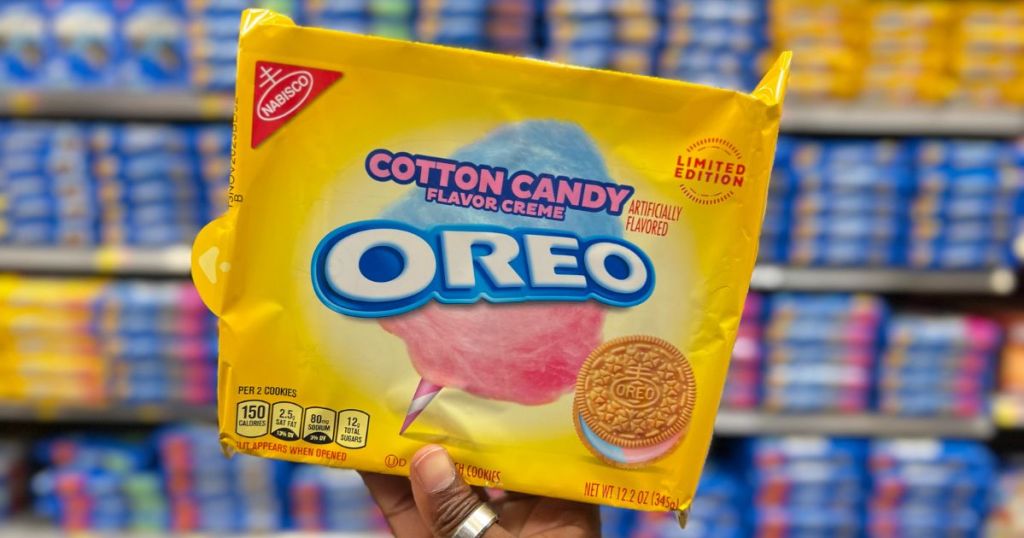 a woman's hand holding a package of Cotton candy oreos with store shelves in the background