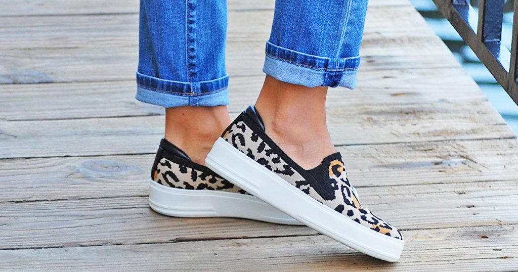 woman wearing a pair of leopard print slip on sneakers