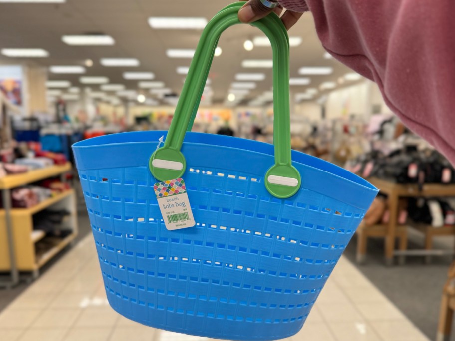 Hand holding blue beach tote bag