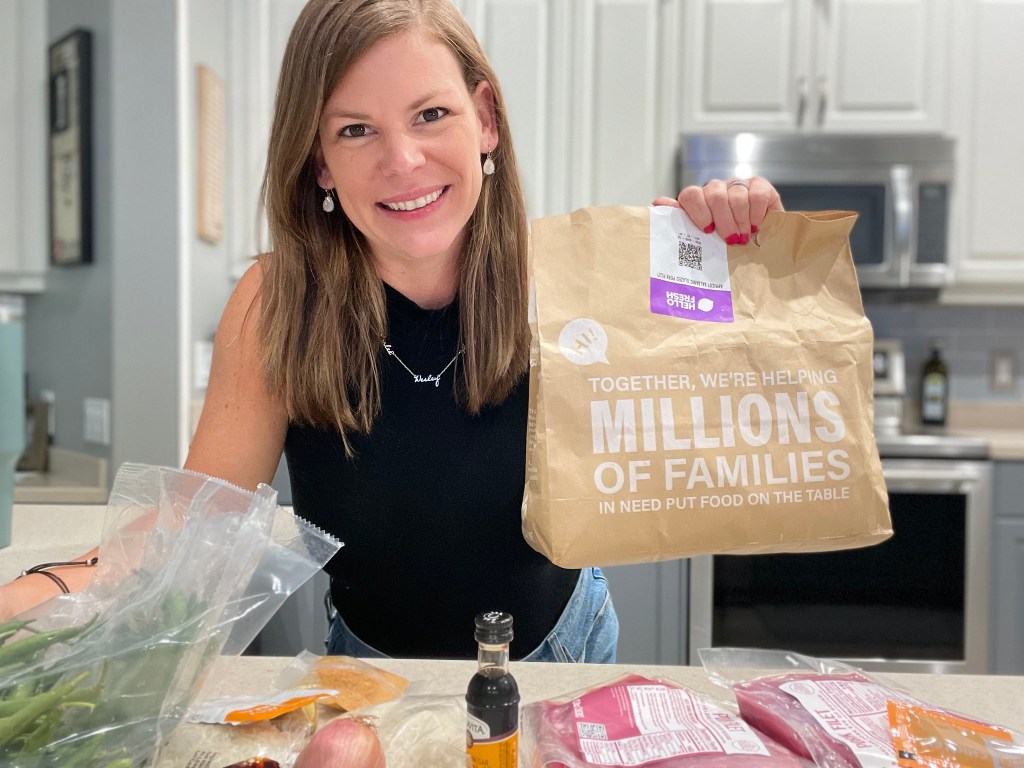 woman holding hello fresh brown paper bag