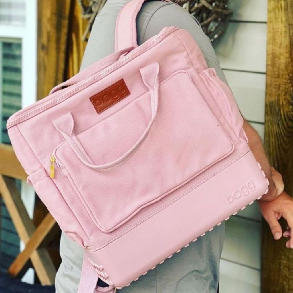 Person carrying a pink Bogg Canvas Backpack bag walking into a house