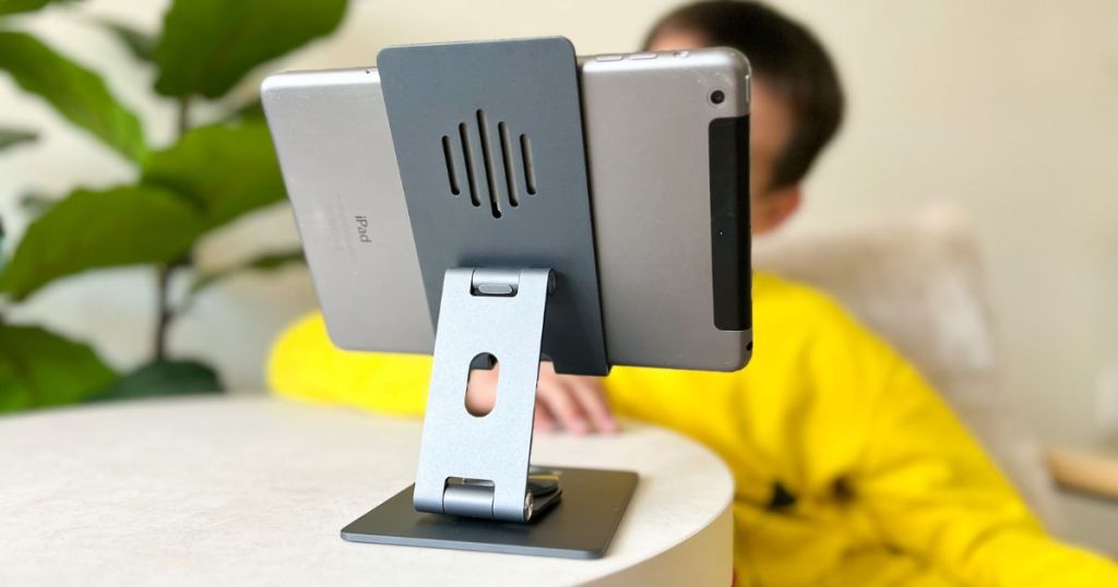 boy in yellow shirt looking at ipad on a stand