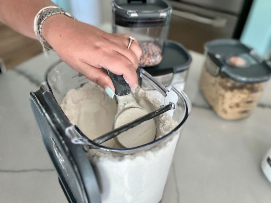 hand using the built in leveling tool to measure flour from a Prokeeper+ Storage Container