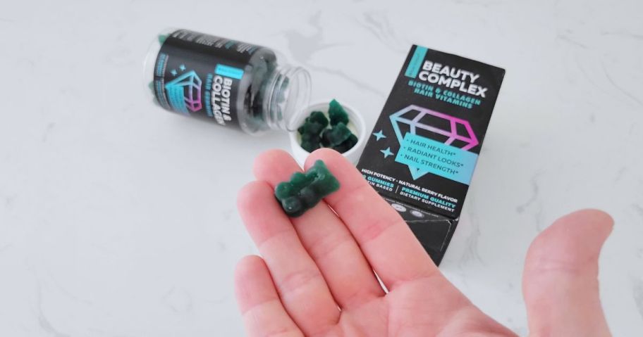 hand holding gummy bear shaped hair supplement