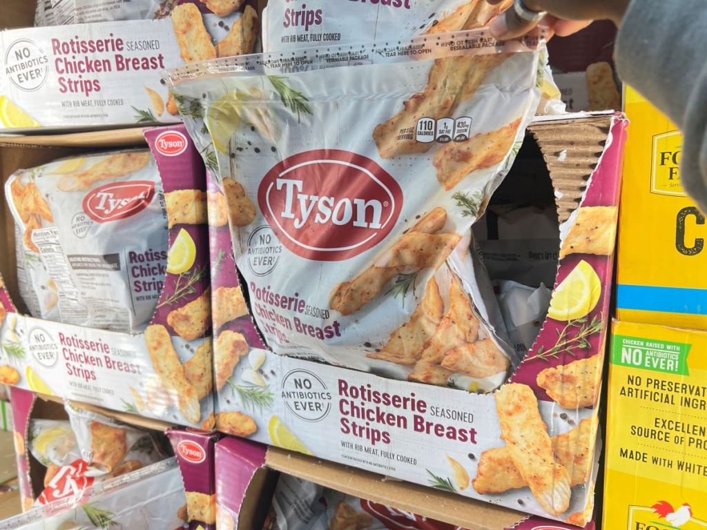 Hand grabbing a bag of Tyson frozen chicken out of a box