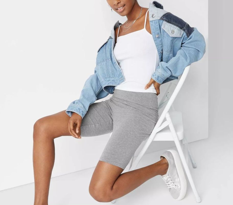 a woman wearing pair of heather gray high rise bike shorts
