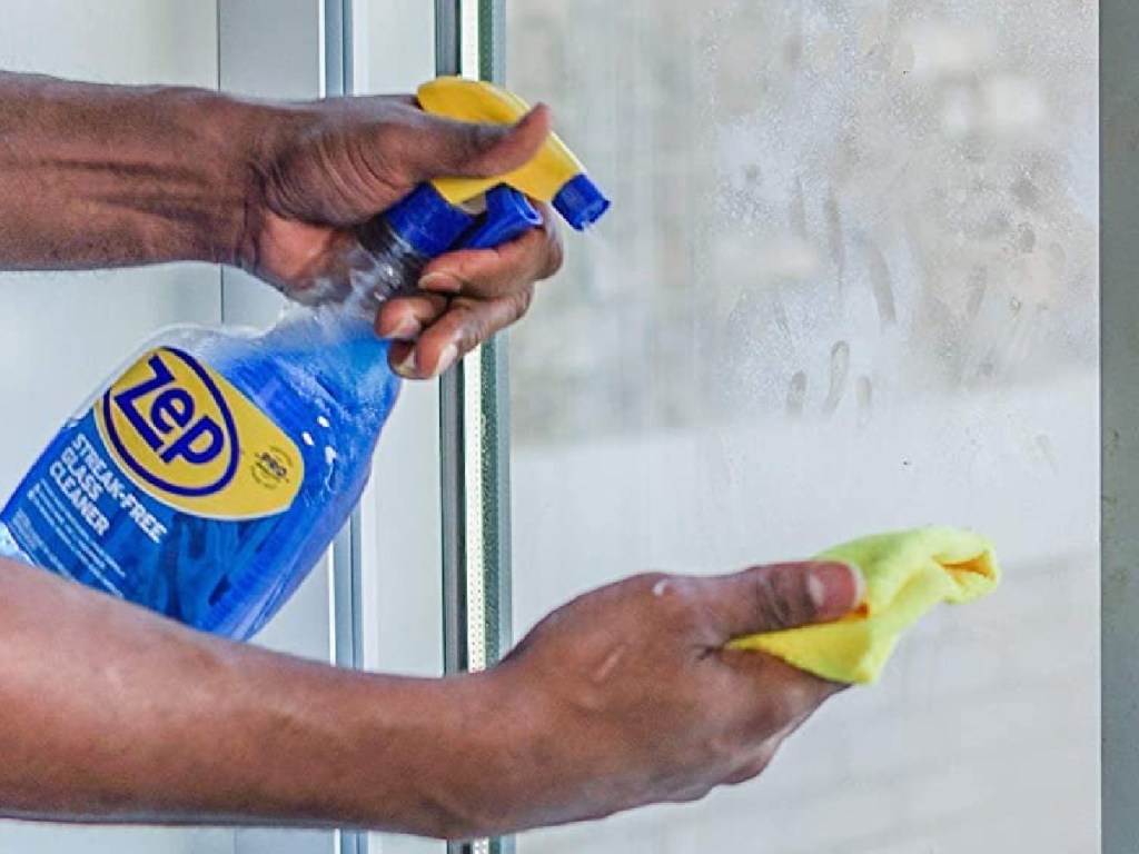 Zep Streak-Free Glass Cleaner sprayed on towel to clean the windows