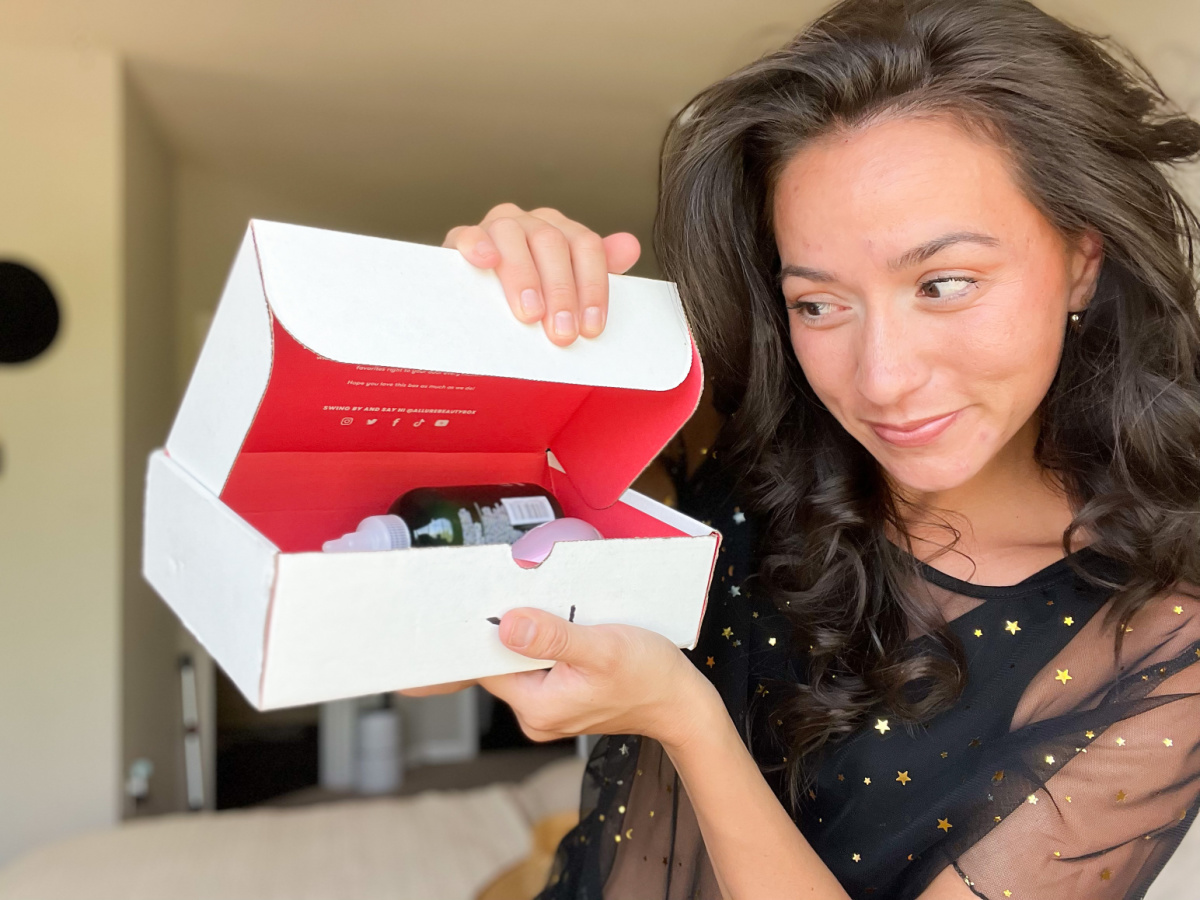 a woman holding an allure beauty box