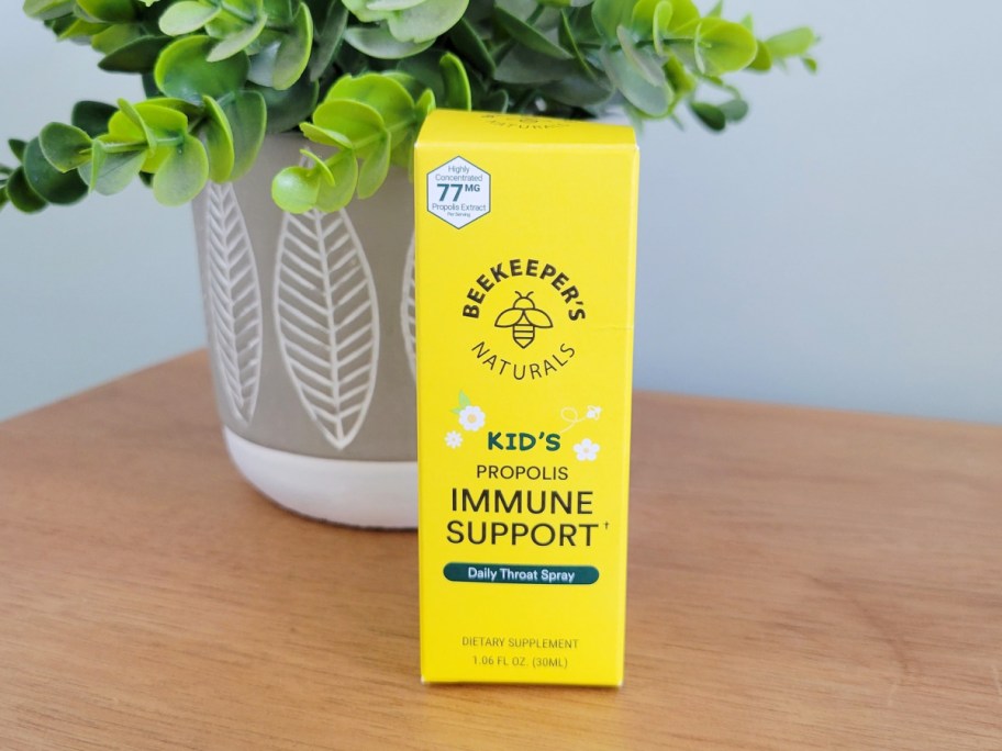 beekeepers kids immune support throat spray inside its box displayed in front of a plant