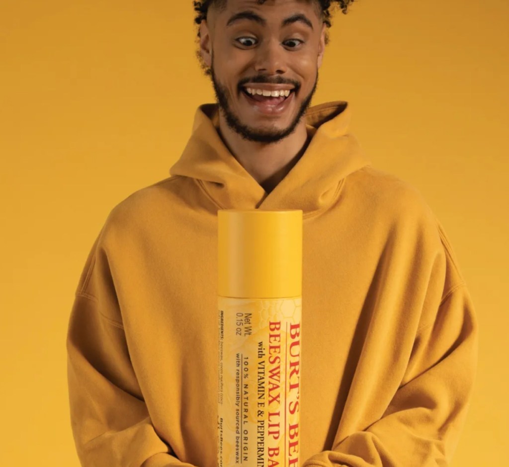 man holding GIANT burts bees tube