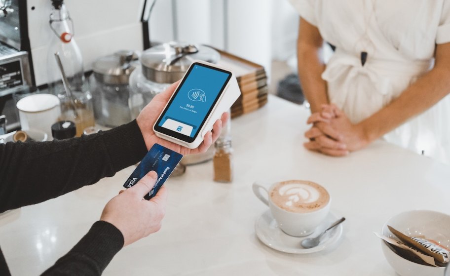 person inserting credit card into payment machine at coffee shop - tipping fatigue