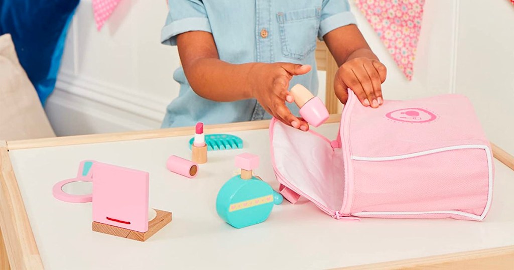 child playing with wooden makeup kit