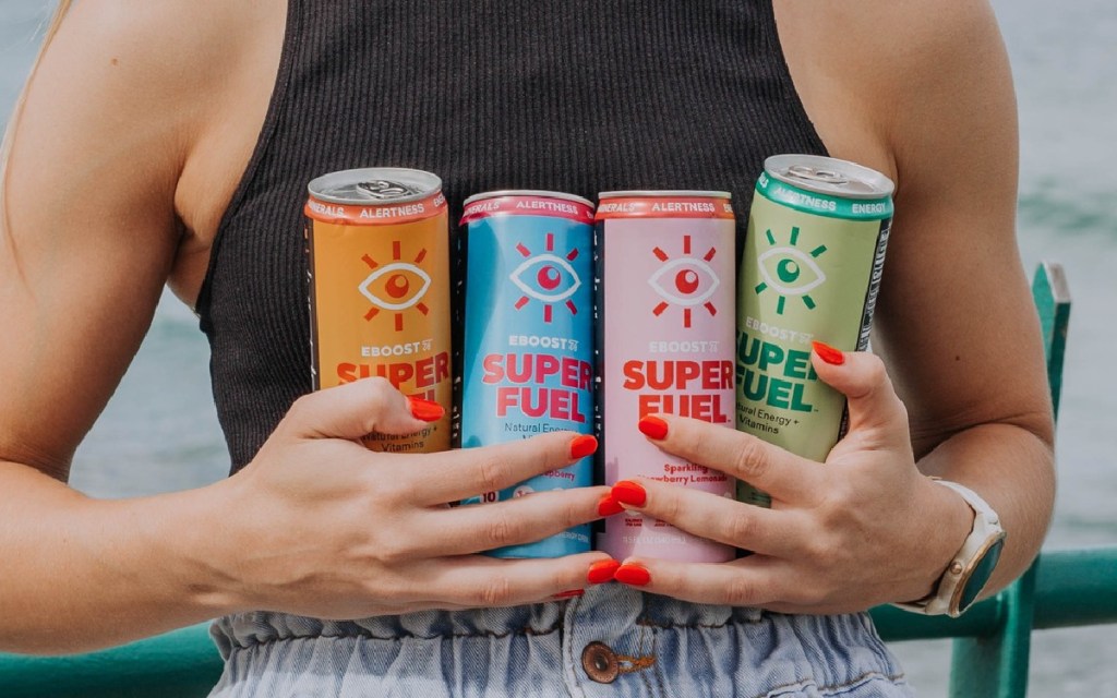 hands holding 4 energy drink cans