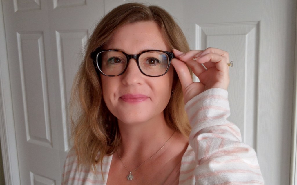 woman holding side of glasses frames