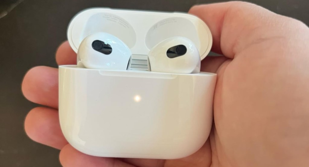 hand holding latest Apple AirPods 3rd Generation with Lighting Charging Case