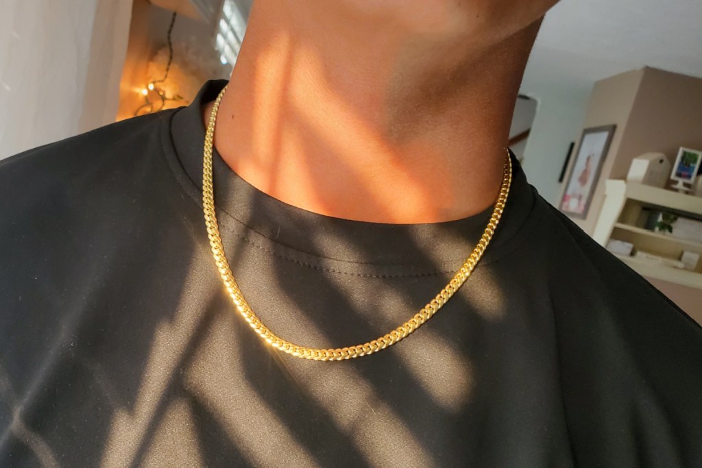 man in black shirt with gold cuban link necklace