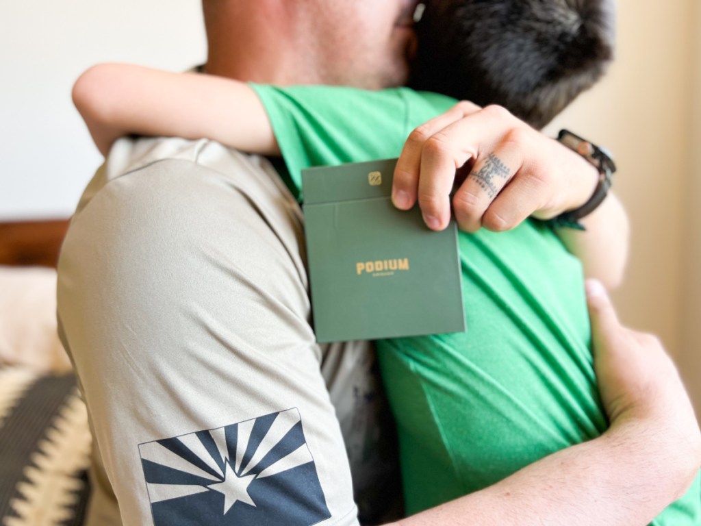 boy hugging dad holding jewelry gift box