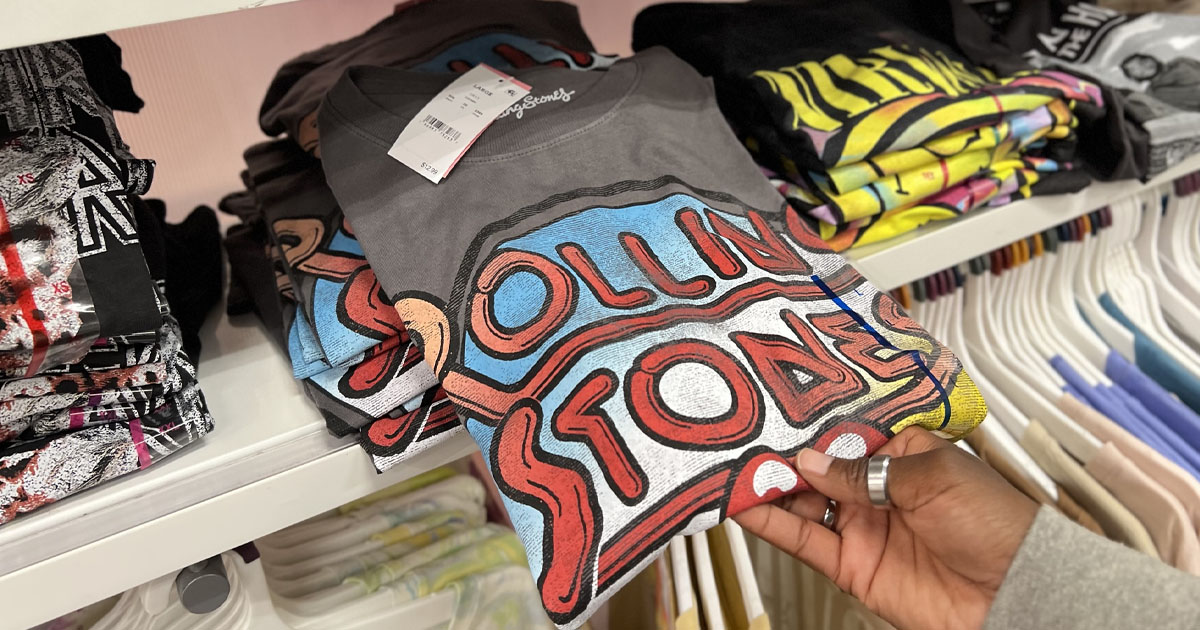 hand pulling rolling stone graphic tee off shelf