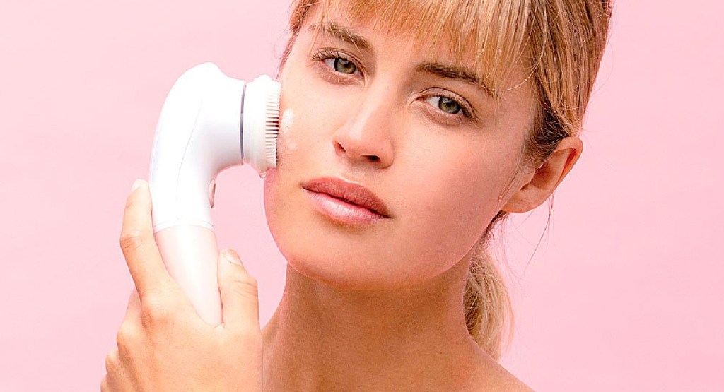 woman using vanity planet cleansing brush on her face