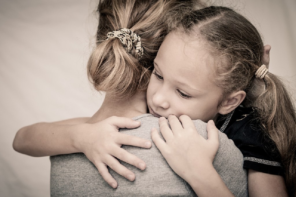 A mom and daughter hugging