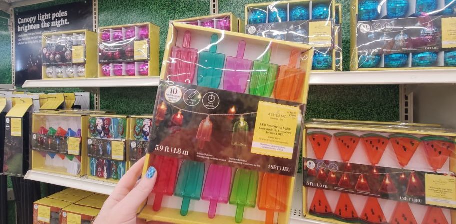 womans hand displaying a box of popsicle string lights