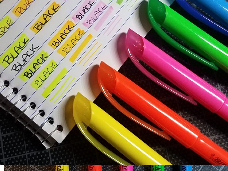 BIC Highlighters next to notebook paper
