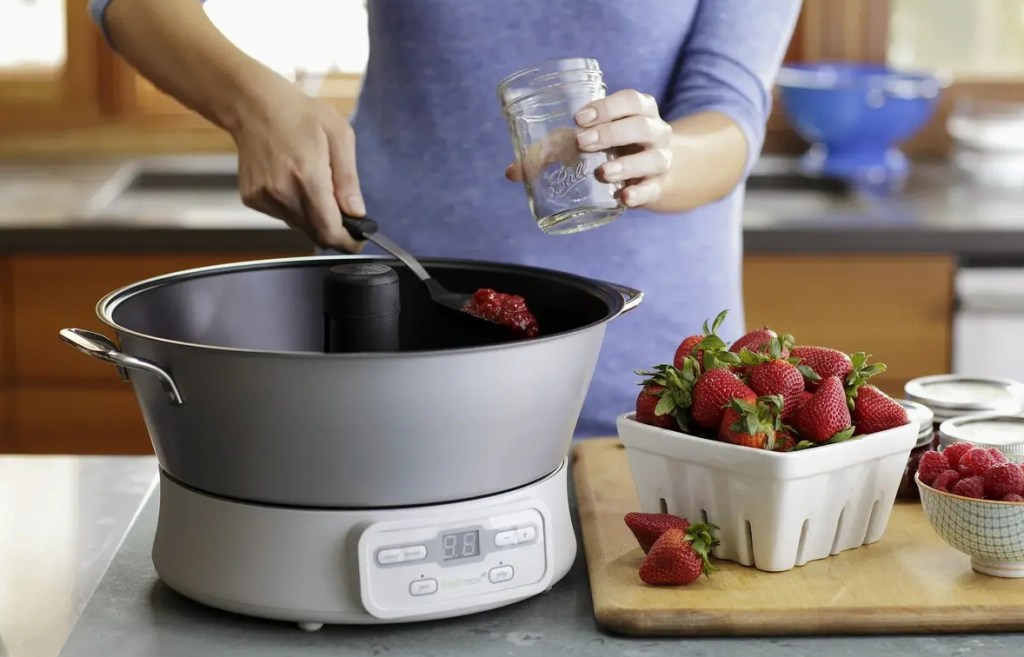 Woman scooping jam out of a jam maker