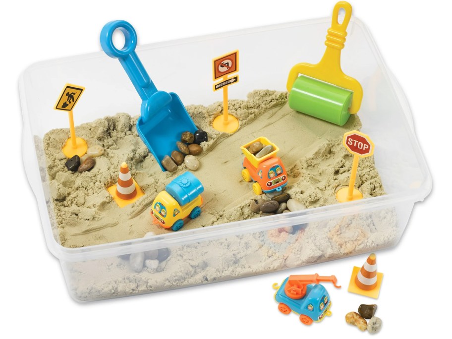 construction themed sensory bin filled with sand