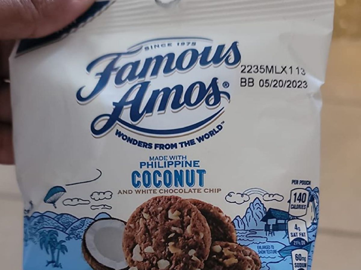 a hand holding a bag of Famous Amos cookies