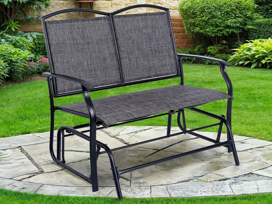 black and grey patio glider chair in a back yard