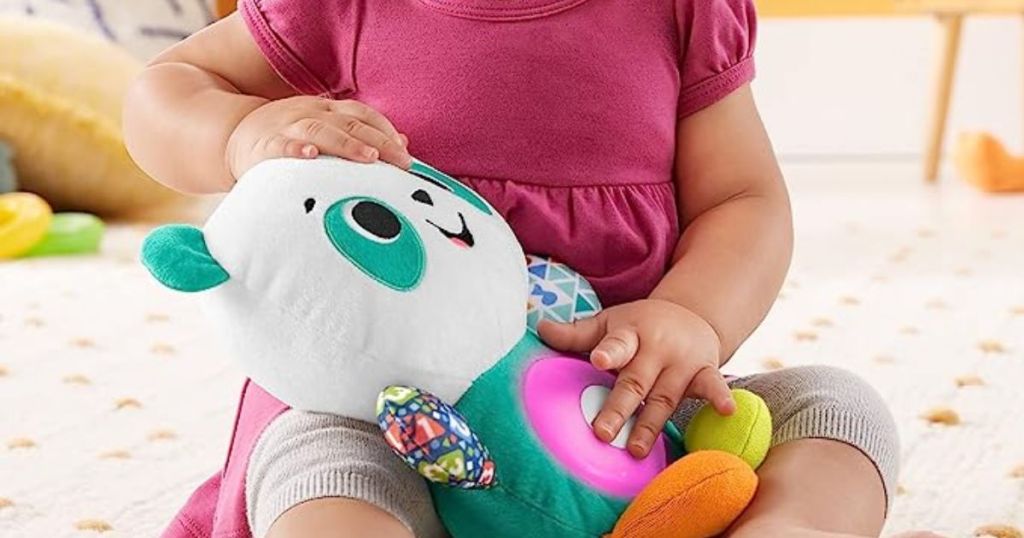 Little girl playing with a Fisher-Price Linkimals Baby & Toddler Toy Play Together Panda Plush With Interactive Music & Lights