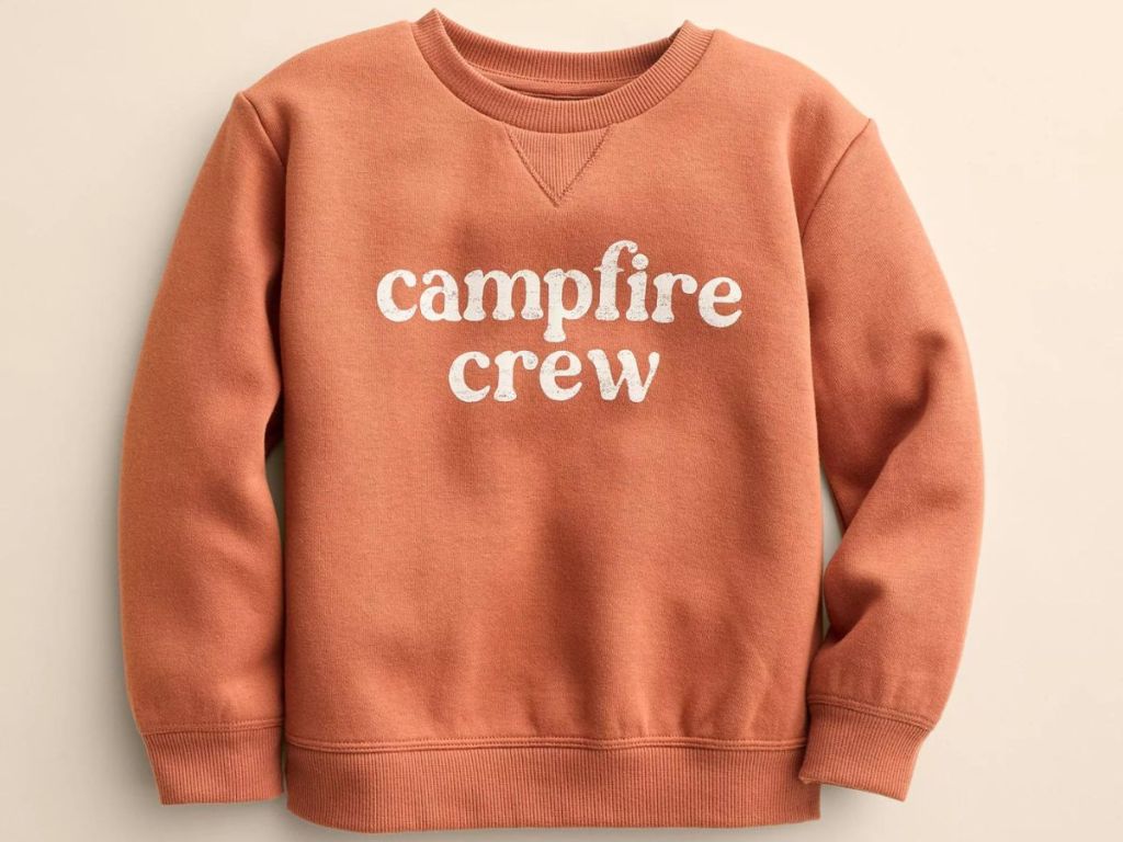 An orange child's sweatshirt with "campfire crew" written on it 