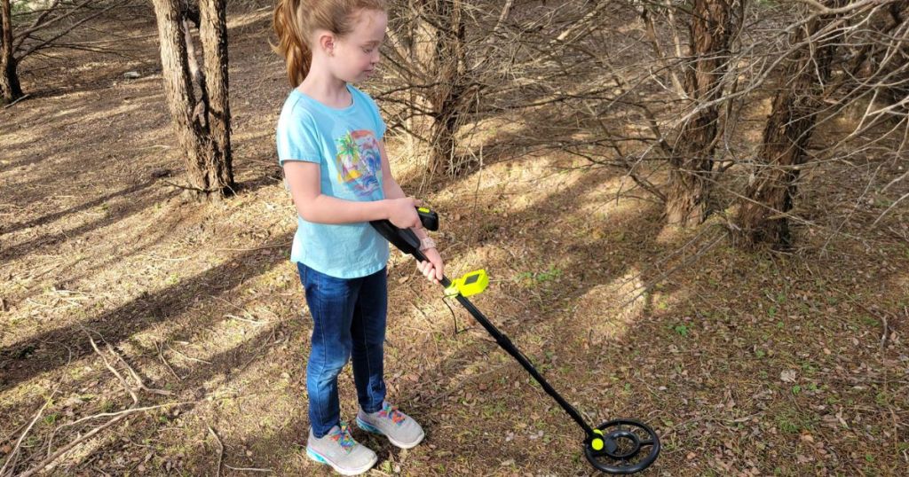 Little girl using a metal detector