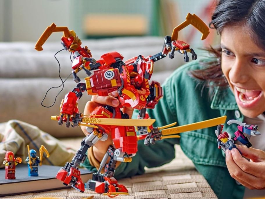 Boy playing with a LEGO NINJAGO Kai’s Ninja Climber Mech Adventure set
