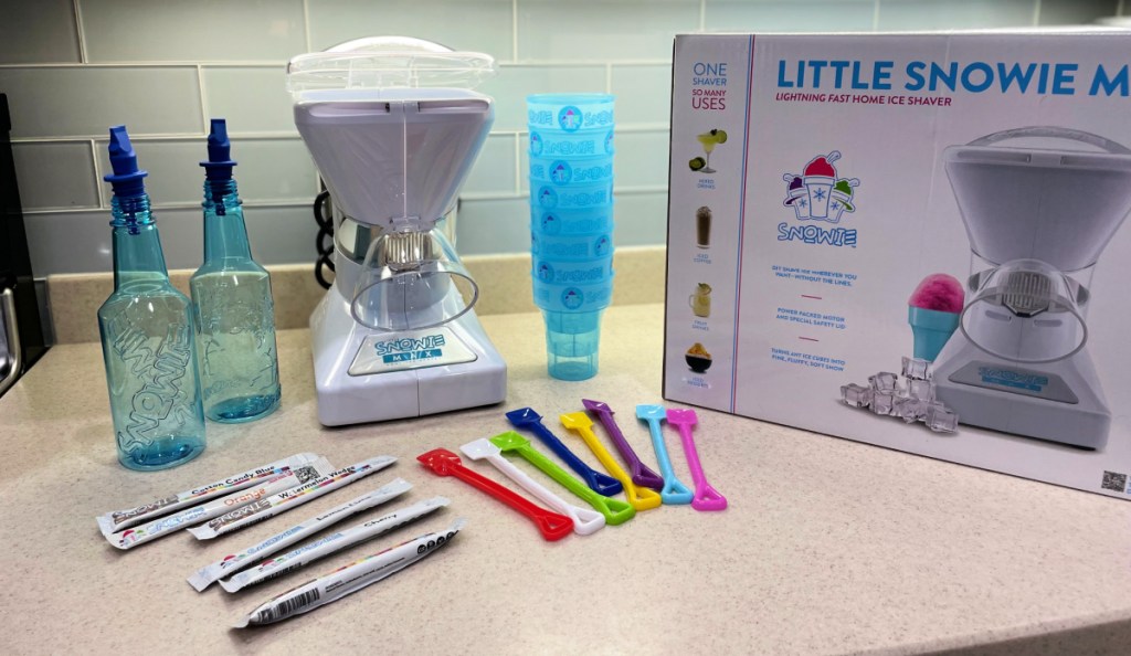 Little Snowie MAX Shaved Ice Machine with accessories on a counter near the box