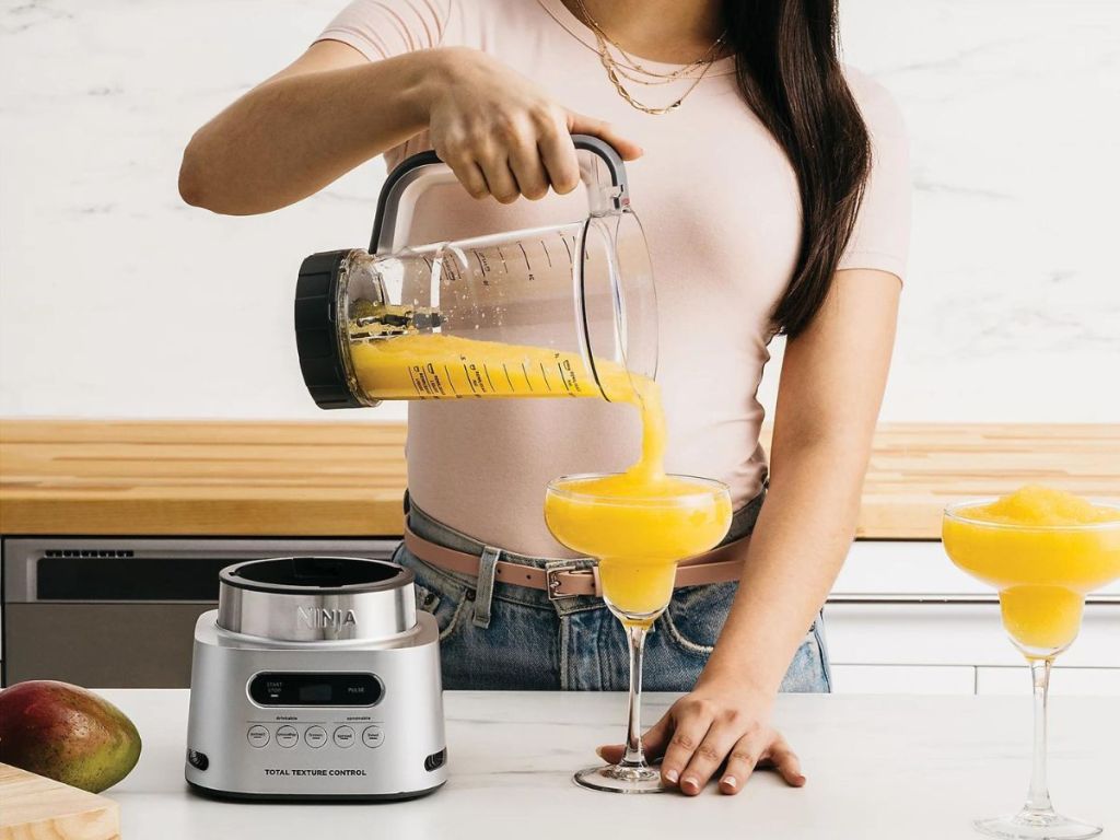 woman pouring margaritta from blender into glass